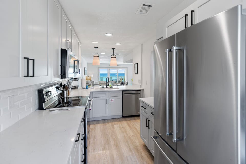 Your modern, fully-equipped kitchen opens to stunning ocean views—perfect for preparing fresh meals while soaking in the coastal scenery through expansive windows.