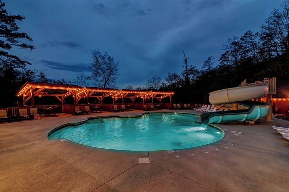 Spacious outdoor resort pool surrounded by mountain scenery, comfortable seating, and plenty of space to unwind after a day of adventure