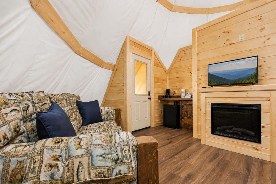 Comfortable Living room with sleeper sofa providing additional sleeping accommodations for families and small groups enjoying a luxury Smoky Mountain glamping experience.