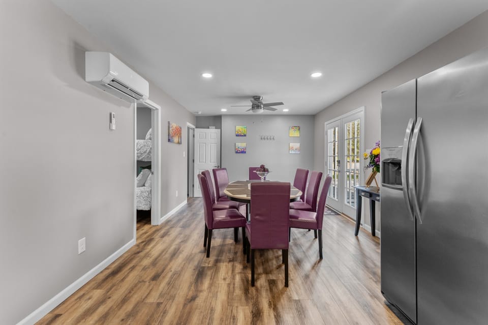 Dining Area: Enjoy meals at this stylish table with vibrant purple chairs and natural light!