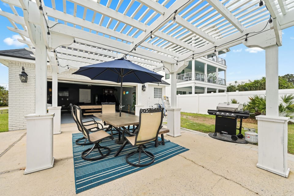 Pergola patio with dining, string lights, and grill—perfect for BBQ nights