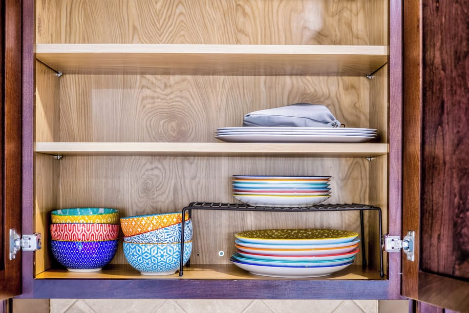 Colorful dishes tucked neatly away, adding a subtle touch of personality to ever