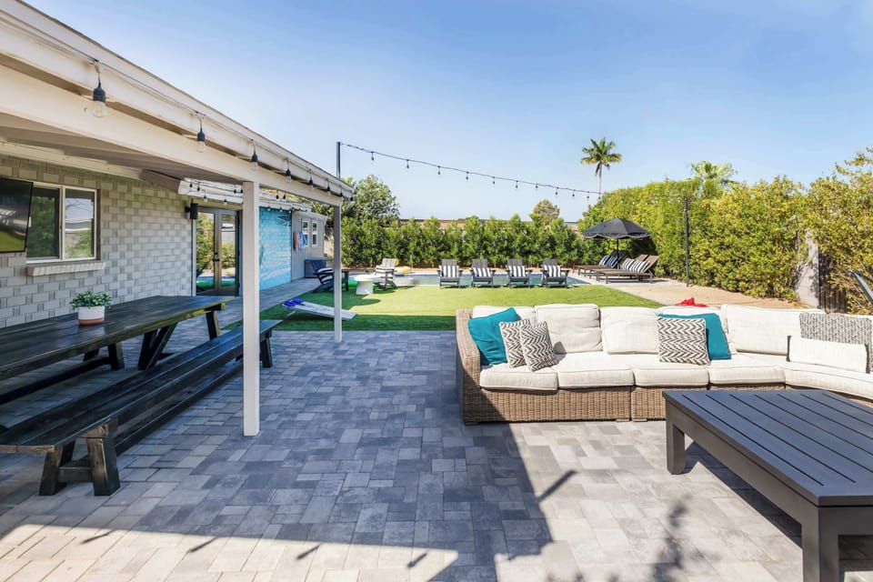 Covered patio and outdoor lounge space that opens up to the pool and backyard. An easy setup for meals, drinks, and spending time outside together.