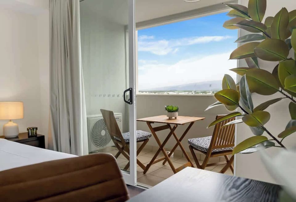 The enclosed balcony offers a sheltered dining nook, perfect for relaxed meals with louvre windows welcoming tropical breezes.