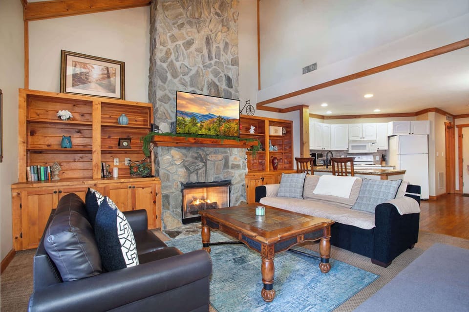 Cozy living room with stone fireplace and TV.