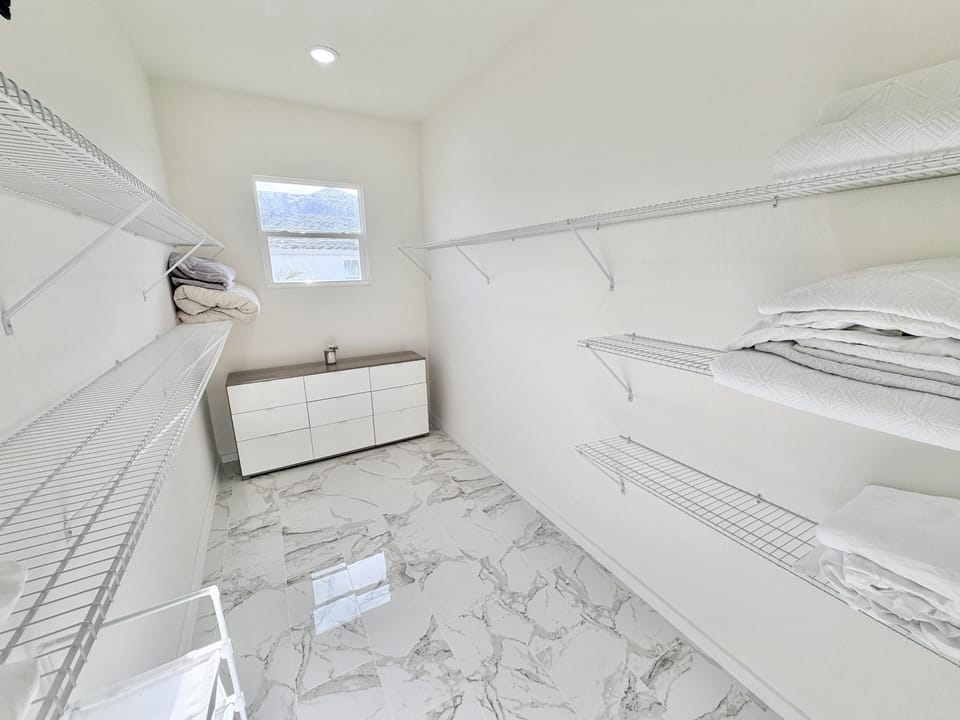 Bright, spacious walk-in closet with sleek marble flooring