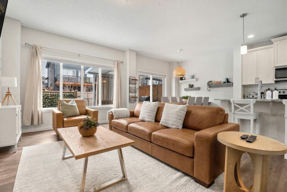 Main floor living room with a 50` Smart TV with cable, gas-lit fireplace, board games, cozy seating options and walkout access to the backyard.