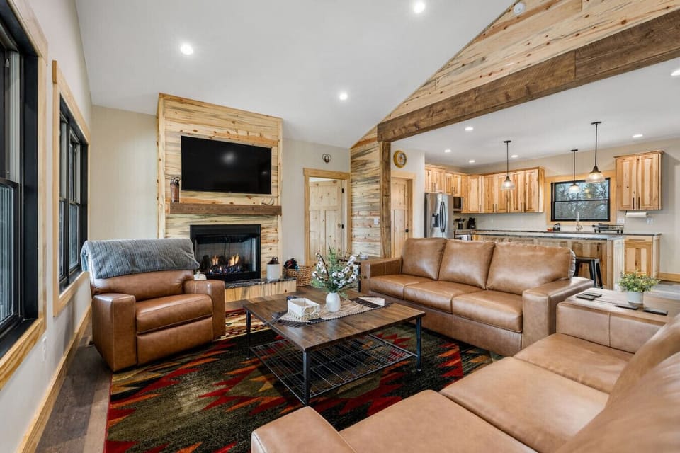 Relax in a warm, modern living space with plush seating, a cozy fireplace, and abundant natural light.