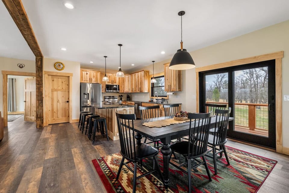 Enjoy a spacious open-concept kitchen and dining area with modern cabinetry, stainless steel appliances, and a stylish wooden table for gathering.