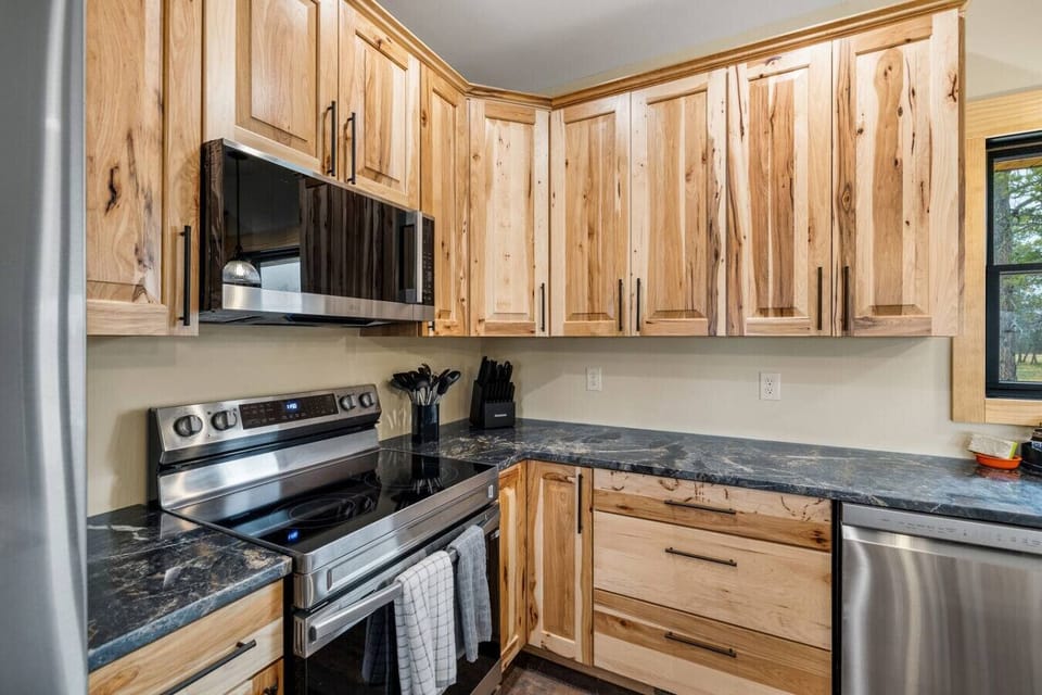 Cook with ease in a modern kitchen featuring sleek cabinetry, stainless steel appliances, and warm wood tones.
