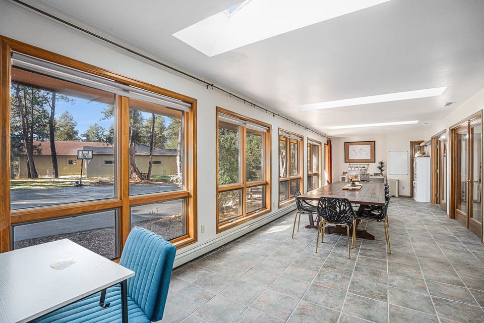 Enjoy this bright, sunlit space perfect for meals, games, or quiet moments, where expansive windows frame peaceful forest views and invite you to slow down and savor your mountain retreat.
