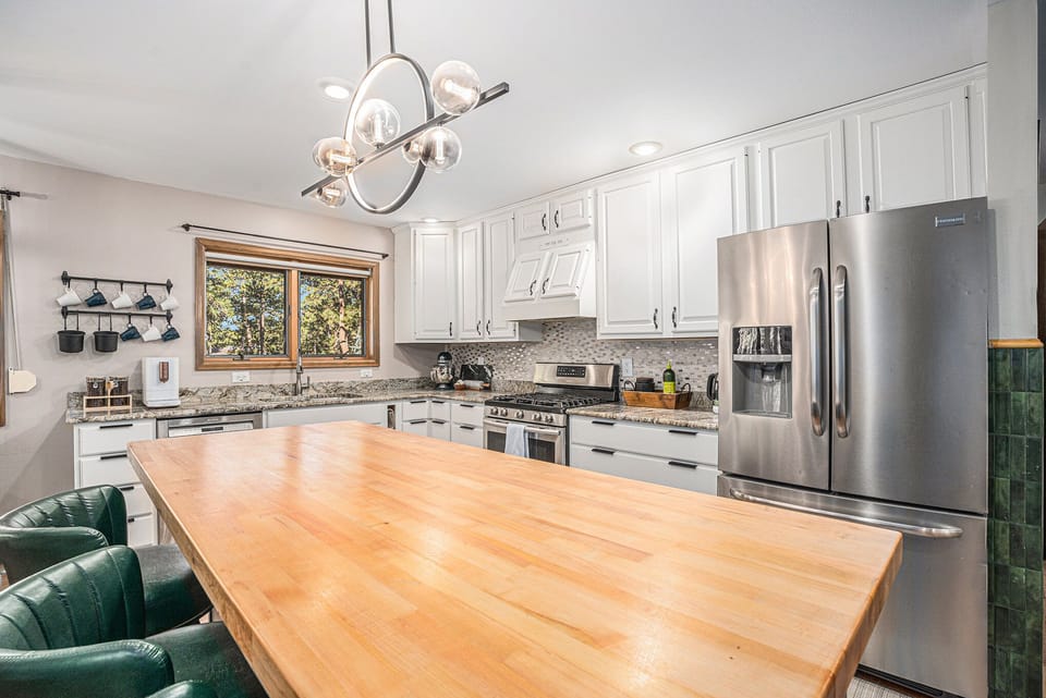 Cook, gather, and connect in this bright, fully equipped kitchen, where forest views, ample counter space, and modern appliances make preparing meals together feel effortless and inviting.