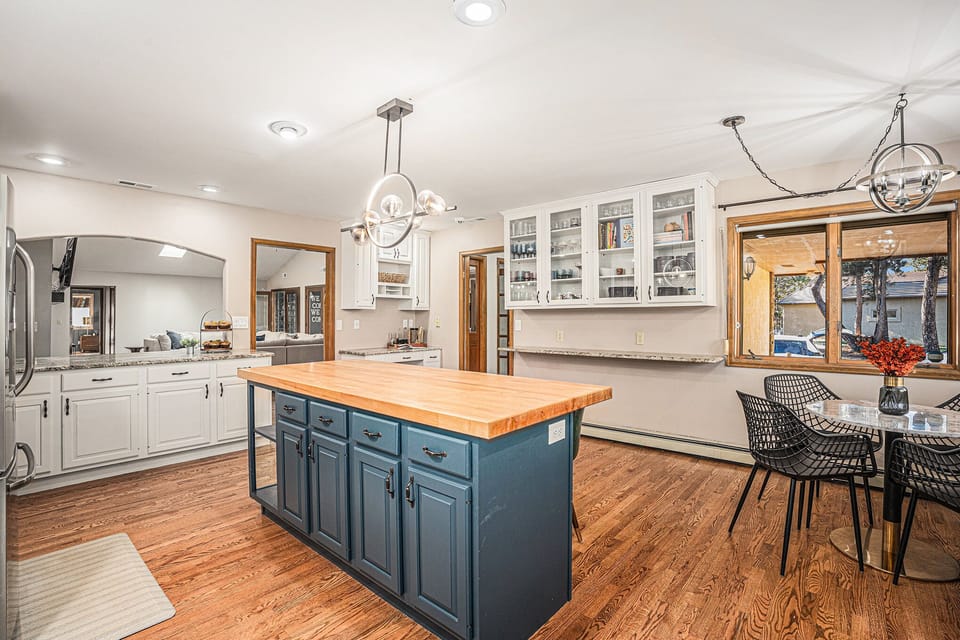 This bright, spacious kitchen invites you to cook, gather, and linger, with a large island, cozy breakfast nook, and forest views that make every meal feel relaxed and connected.