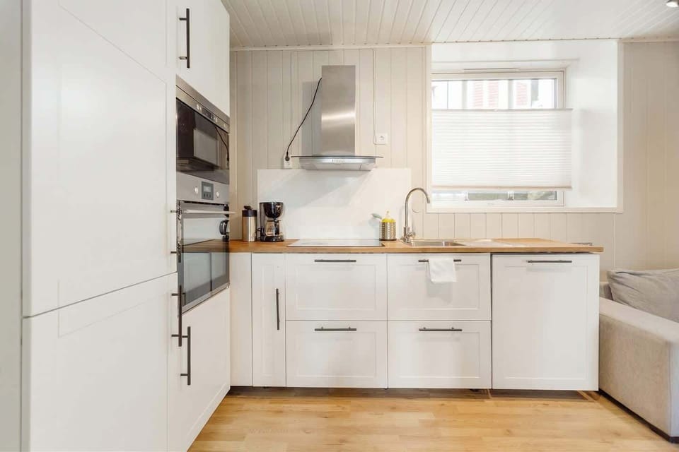 Kitchen with oven, range hood, sink, and wooden countertops