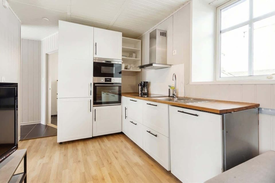 Modern kitchen with full-size fridge, oven, microwave, and dishwasher