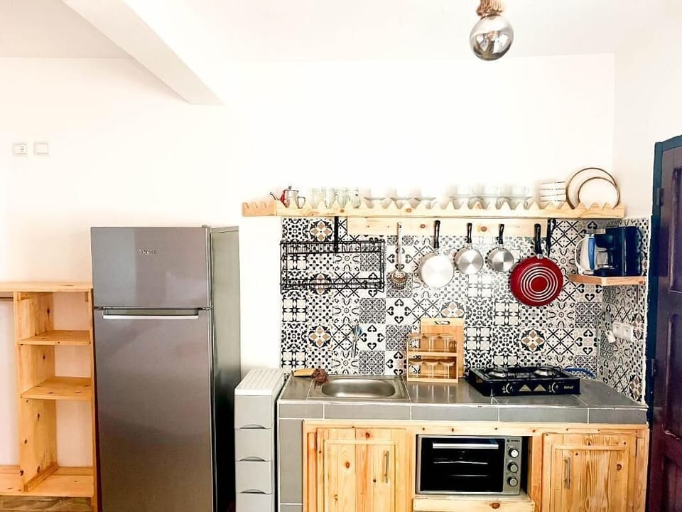 Family Studio, Partial Sea View | Private kitchen | Fridge, cookware/dishes/utensils, cleaning supplies, dining tables
