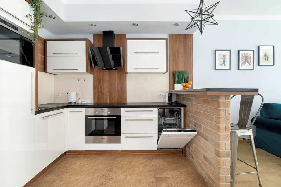 A fully equipped kitchenette with integrated appliances, including an oven and a modern black extractor fan.