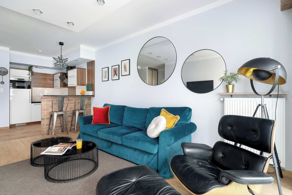 A wide-angle shot of the living space highlighting the open-plan layout, circular coffee tables, and elegant mirrors on the wall.