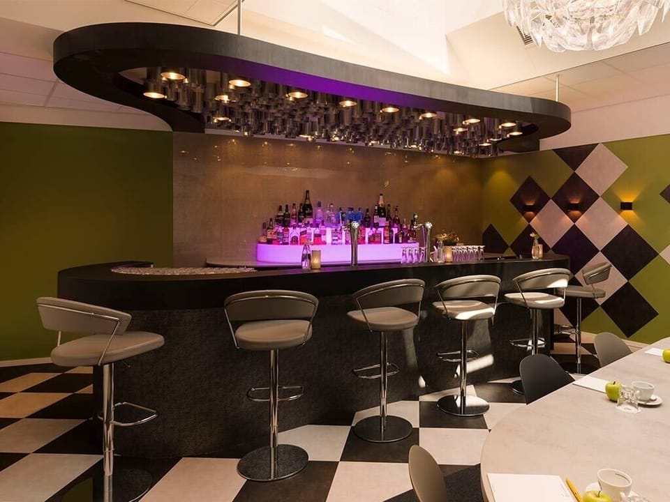 Unwind with crafted drinks beneath chic lighting and stylish seating.