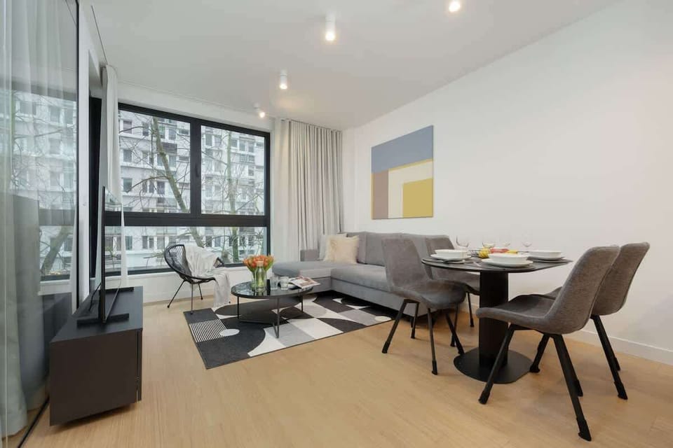 Cosy living room with a gray sofa, a round coffee table, and modern wall art.
