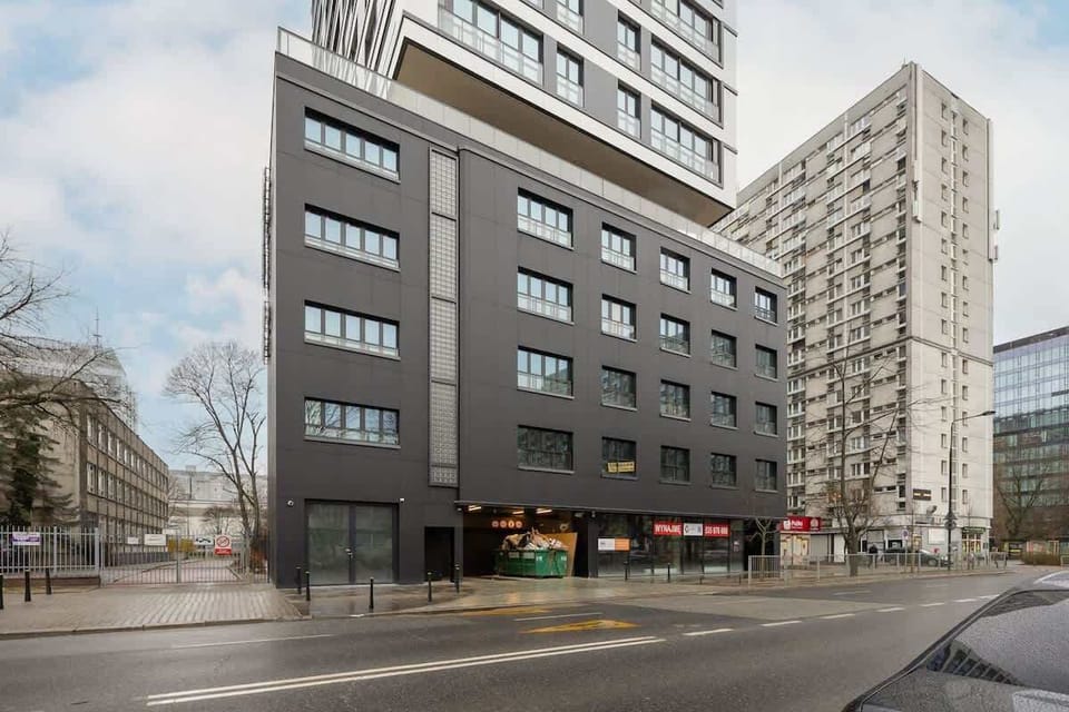 Modern apartment building with large windows and a sleek black facade.