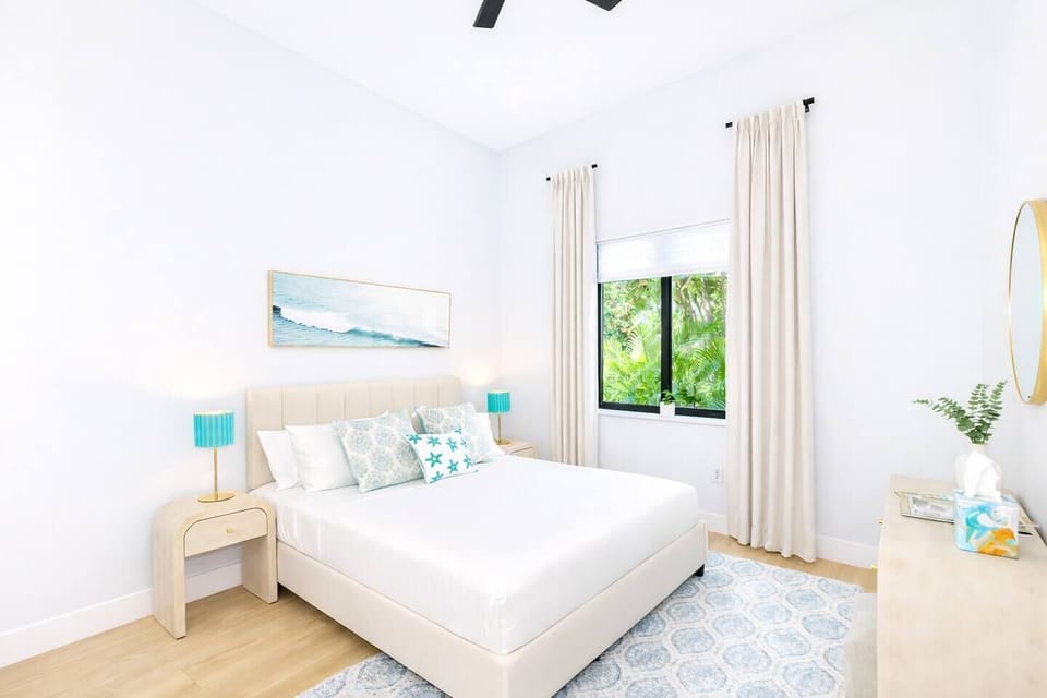 Third bedroom features another bright window view of the greenery outdoors and pulldown sheer shade. Queen bed with pullout trundle.