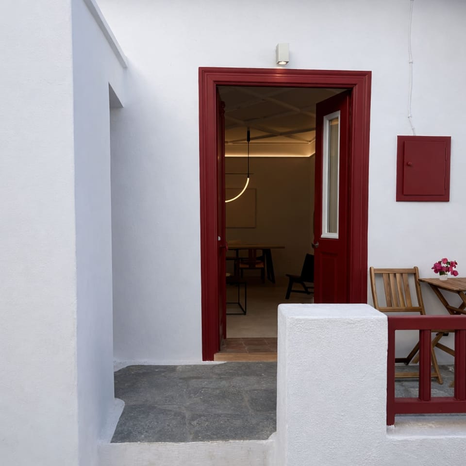 Clean, whitewashed exterior with bold accents reflecting the authentic Mykonos style.