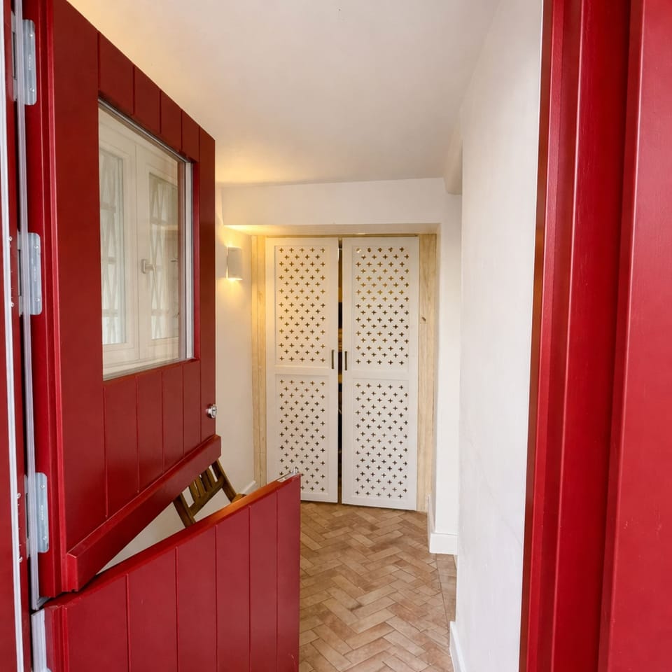 Distinctive red door entryway adding charm and personality while leading into the stylish interior.