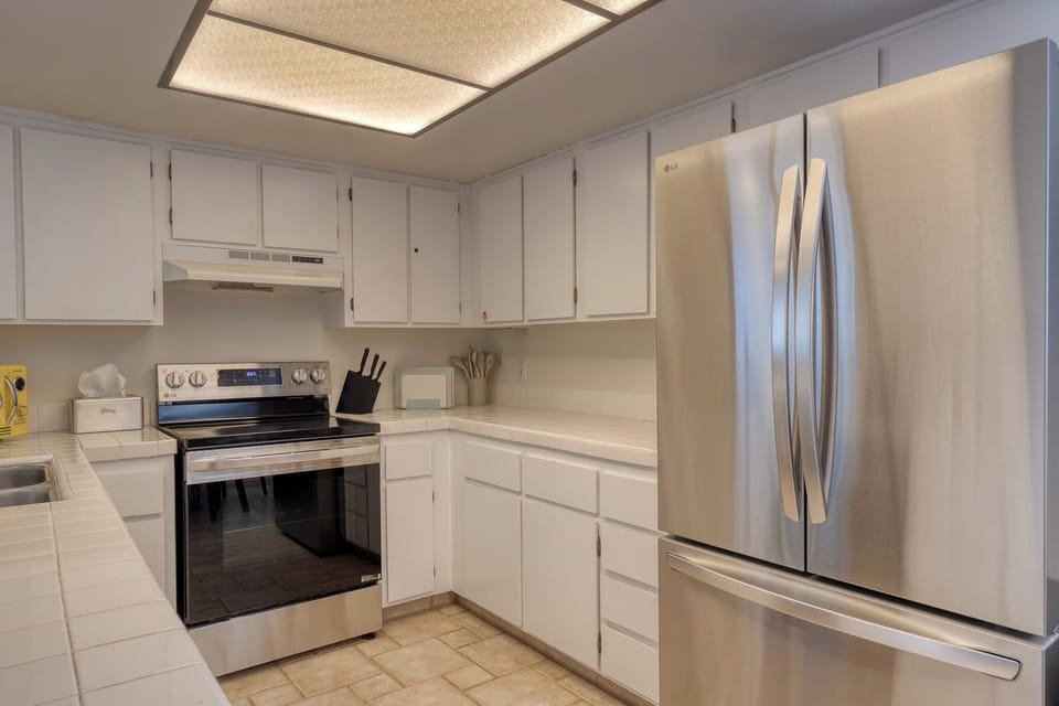 Step into your fully equipped kitchen with sleek stainless appliances and crisp white cabinetry, perfect for preparing meals during your stay.