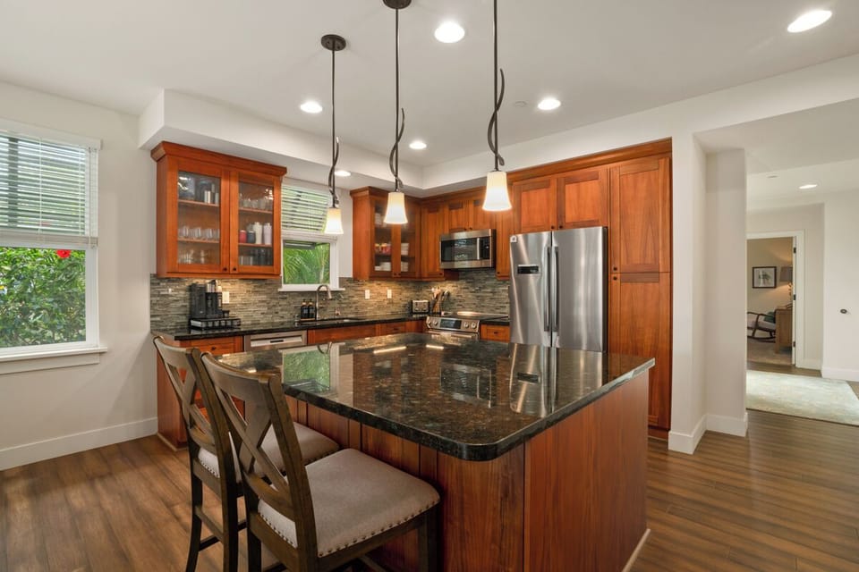 Your gourmet kitchen awaits with granite counters, rich wood cabinets, and stainless steel appliances perfect for creating memorable meals together.