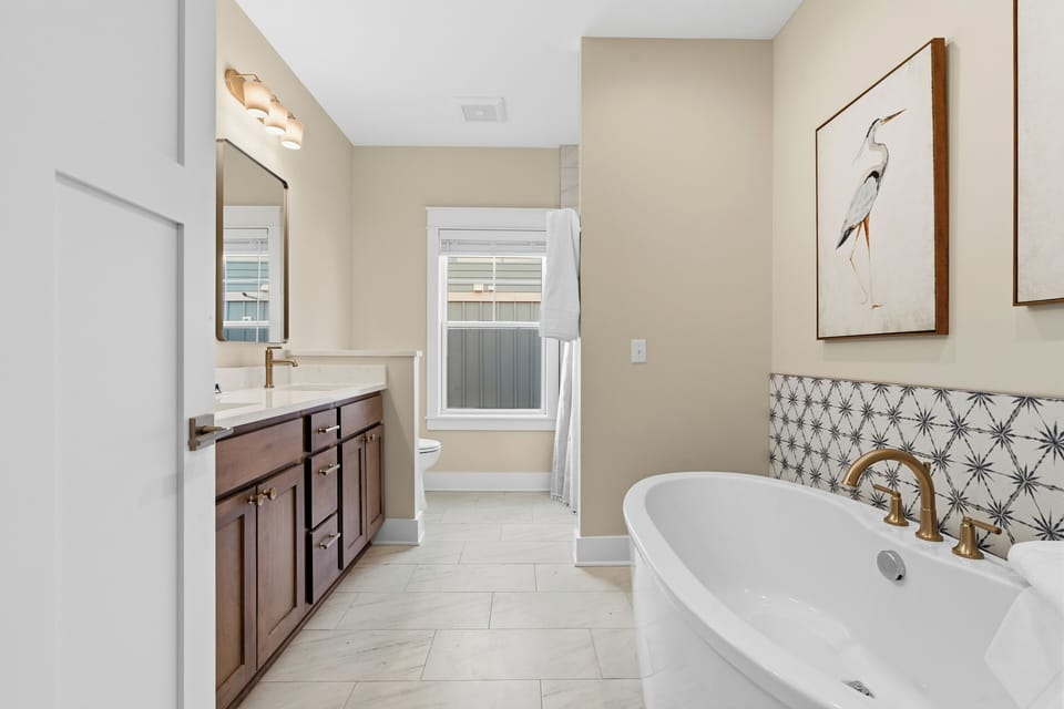 Spa inspired bathroom with freestanding soaking tub and designer tile
