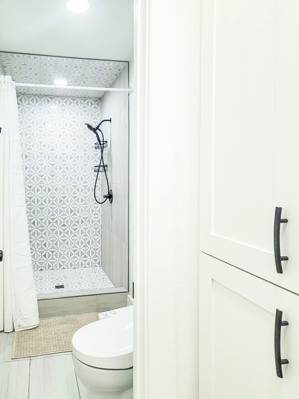 Your private bathroom features a stunning geometric-tiled shower and modern fixtures for a refreshing start to each day.
