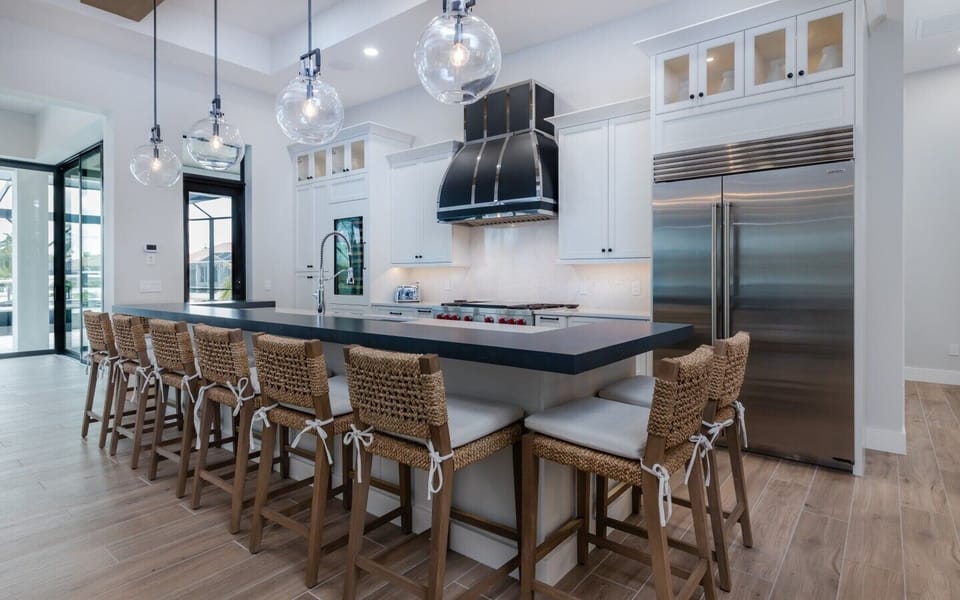 Gourmet kitchen featuring a large island with seating for six, Wolf gas range, Sub-Zero refrigerator, and custom cabinetry.
