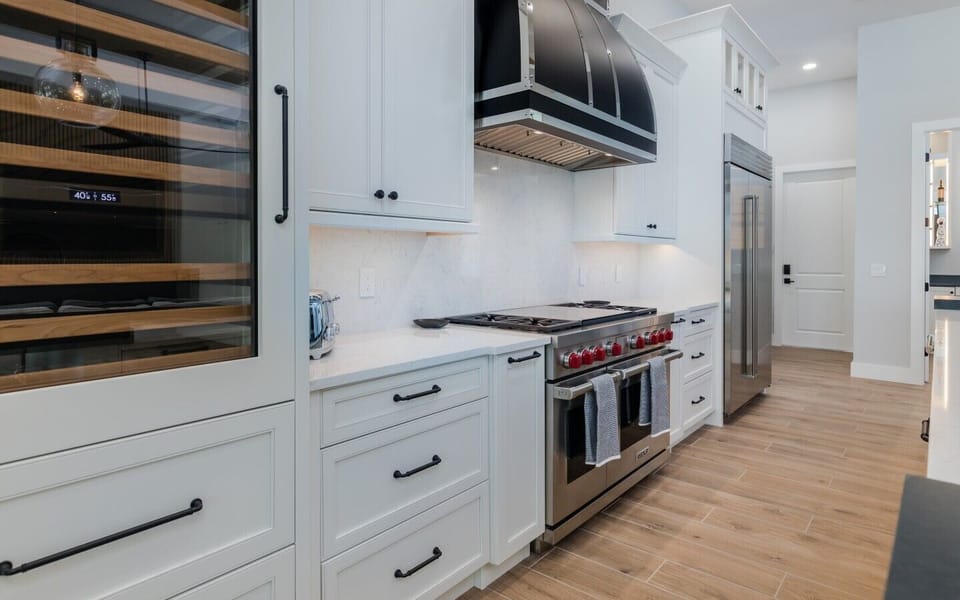 Luxury gourmet kitchen with Wolf gas range, Sub-Zero refrigerator, custom cabinetry, quartz countertops, and premium appliances.