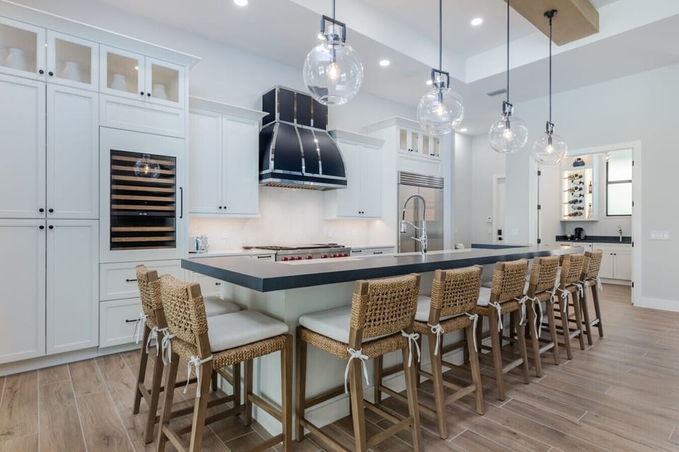 Gourmet kitchen with a large center island, seating for six, Wolf gas range, Sub-Zero refrigerator, and custom cabinetry.