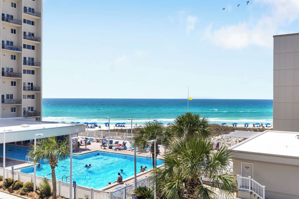 Beautiful beachfront view showcasing the pristine white sand beach and sparkling turquoise waters just steps from the property.