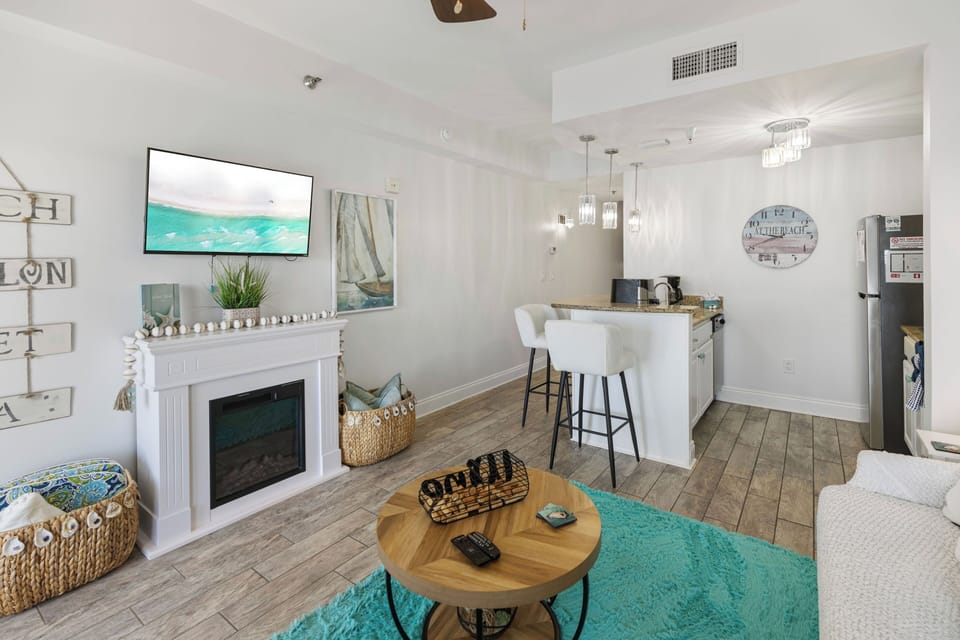 Relax in your coastal-inspired living space with cozy fireplace, modern kitchen, and beach-themed touches throughout.