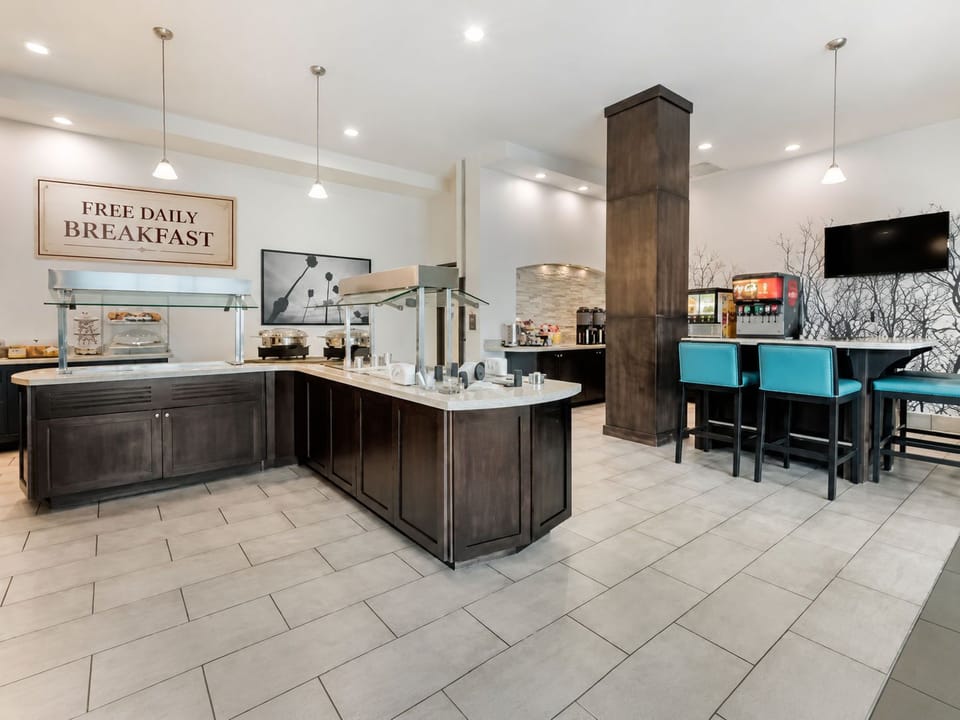 Breakfast and social area with buffet counter, pendant lights, and turquoise bar seating