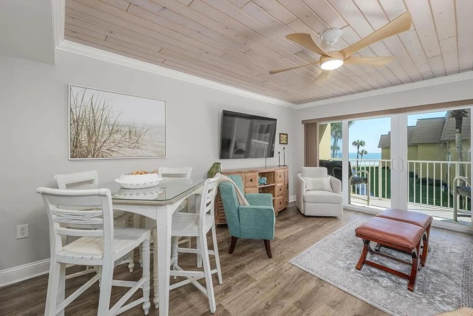 Bright living and dining area with waterfront views and cozy seating