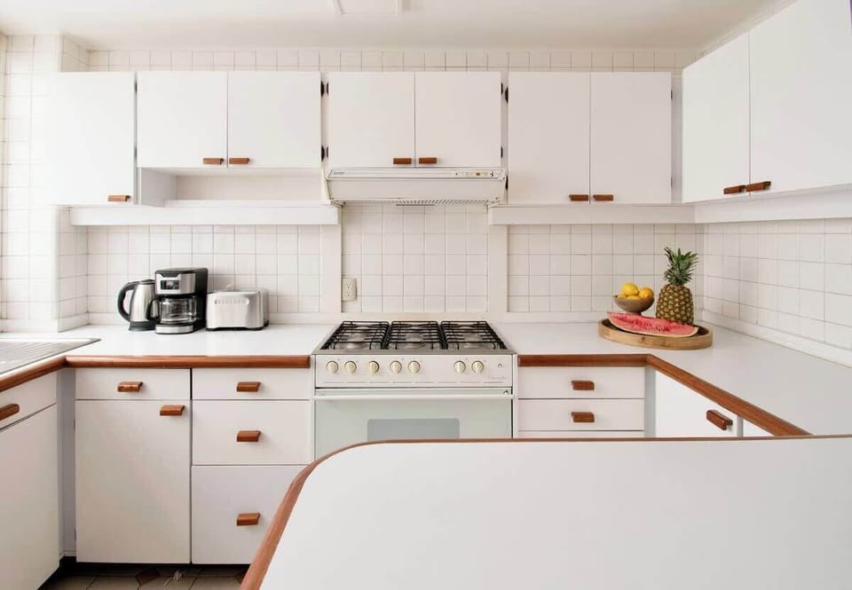 A clean and elegant kitchen designed for easy cooking, featuring a full-size stove and plenty of space to prepare your favorite meals.