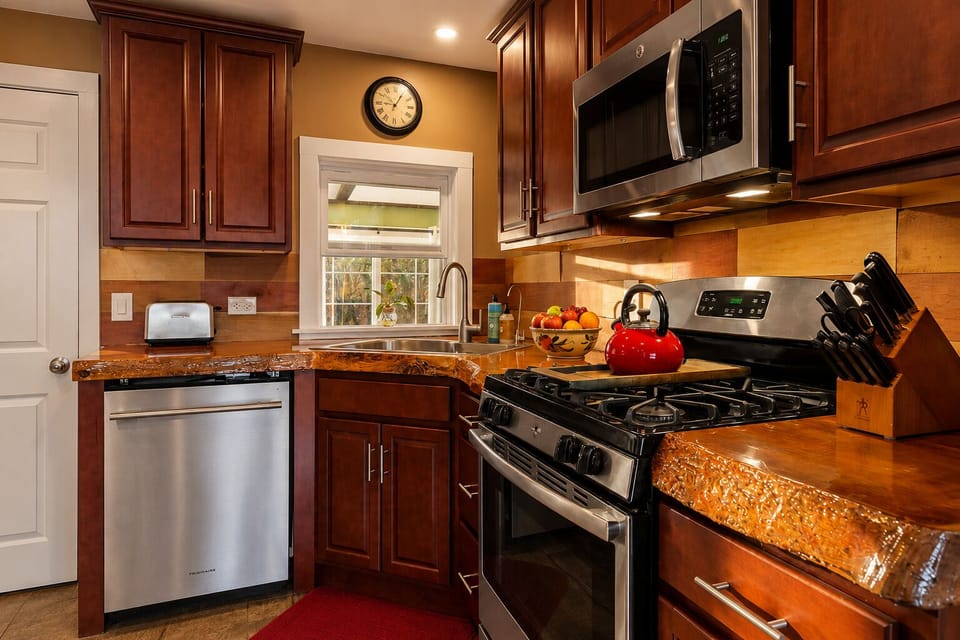 Warm gourmet kitchen with stainless appliances and rich wood finishes
