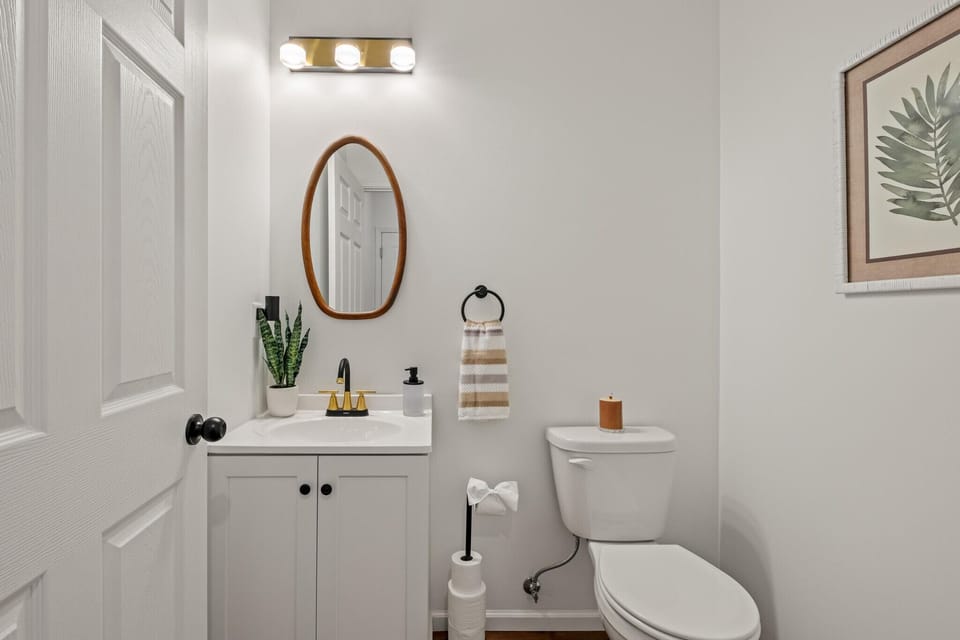 Fresh bathroom with modern vanity, round mirror, and simple décor.