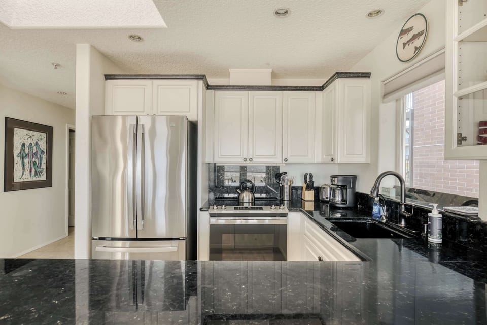 Bright, modern kitchen featuring stainless steel appliances, granite countertops, and ample cabinet space—perfect for cooking in comfort.