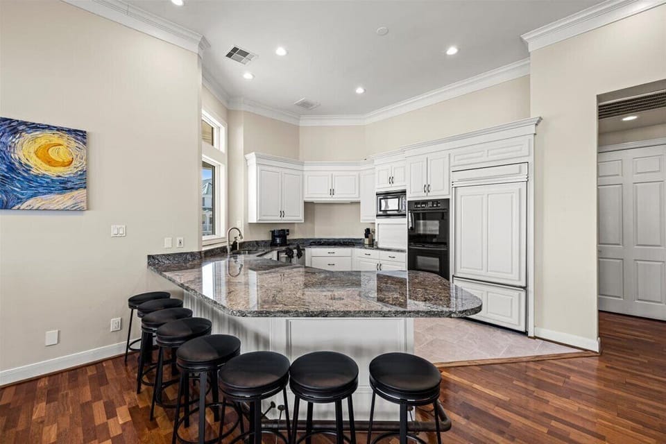 Modern kitchen with bar seating, stainless appliances, and open design
