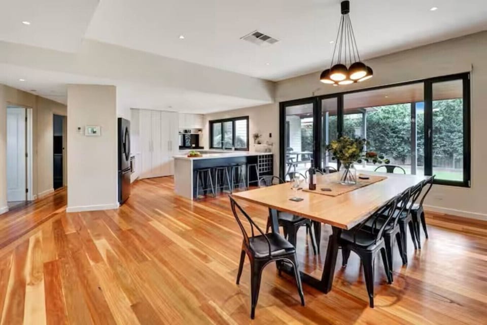 Spacious open plan kitchen and dining area with large island bench and garden outlook at Banksia House High Country Retreat holiday accommodation in Mansfield, Victoria’s High Country