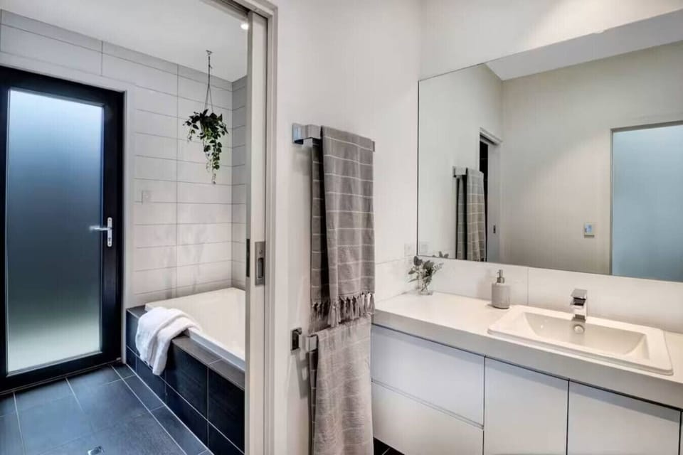 Modern main bathroom featuring a built-in bath, separate shower, vanity, and clean contemporary finishes at Banksia House High Country Retreat in Mansfield Victoria.