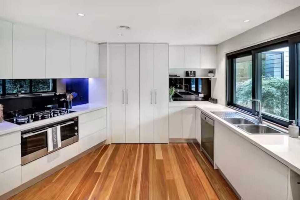 Modern fully equipped kitchen with stone benchtops, quality appliances and garden outlook at Banksia House High Country Retreat holiday accommodation in Mansfield, Victoria’s High Country.