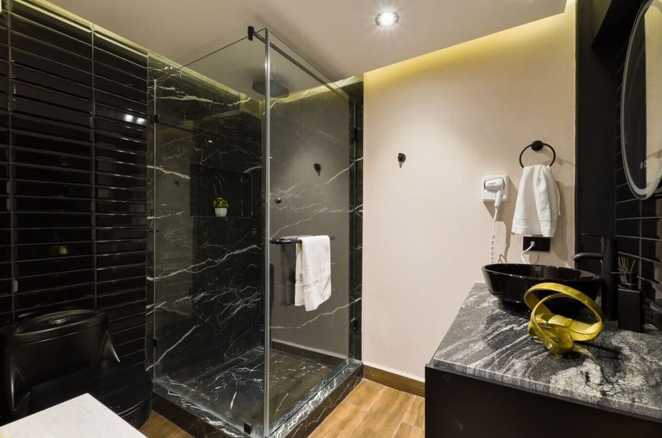 Baño completo con agua caliente, toallas limpias y secadora de cabello para tu comodidad e higiene personal.