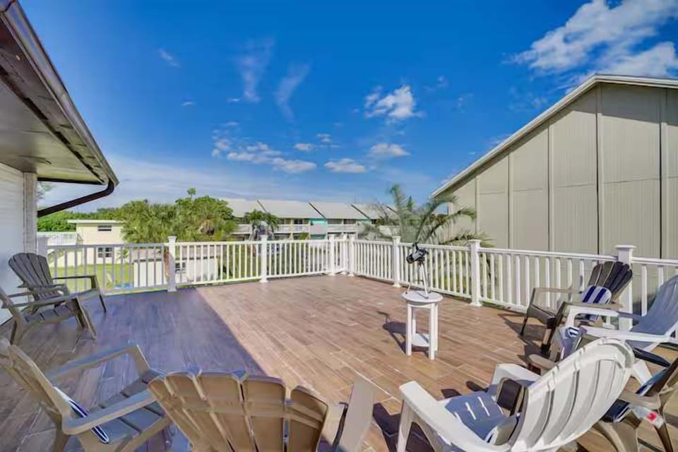 Spacious outdoor deck with seating and a telescope for relaxing and stargazing.