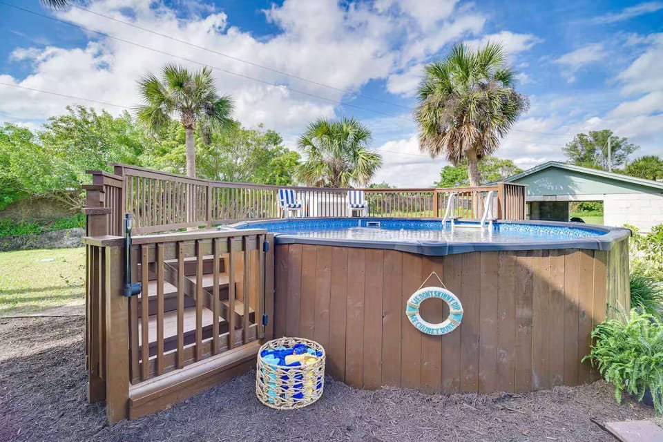 Above-ground pool with deck seating surrounded by palm trees for a relaxing outdoor experience.
